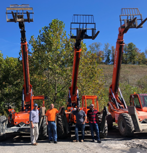 Three cranes beside four crane operators.