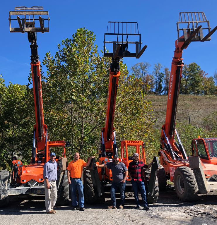 Three cranes beside four crane operators.